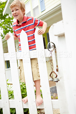 Buy stock photo Happy boy, fence and waiting with joy for holiday, weekend or playful summer in backyard. Young, child or kid with smile on wooden barricade for fun childhood, special day or fresh air in garden