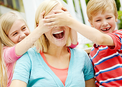 Buy stock photo Two young children playfully covering their mother's eyes