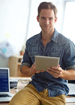 Buy stock photo A young man reading his text messages while standing in his office