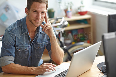 Buy stock photo A young man working on his laptop in the office