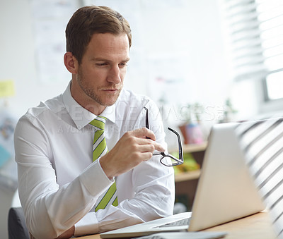 Buy stock photo A young businessman working on his laptop in the office