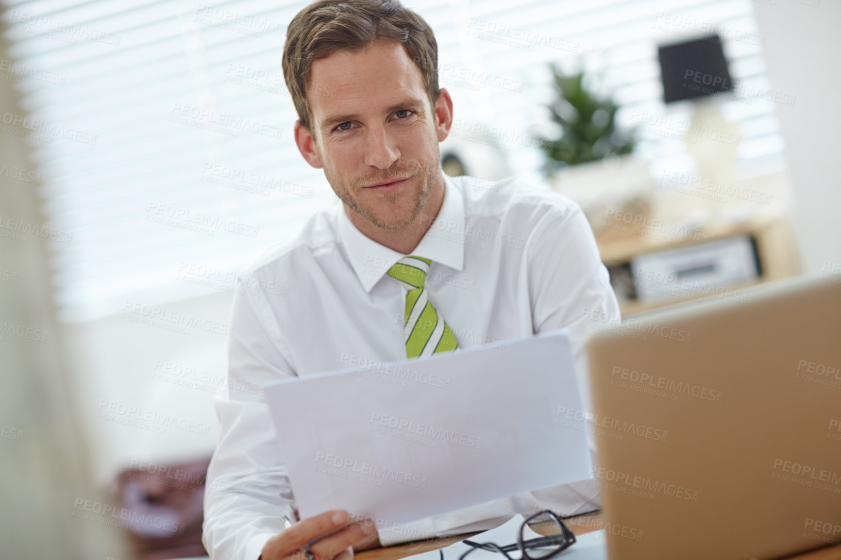 Buy stock photo Man, document and happy with portrait in office with laptop, proposal and planning at media company. Person, writer and smile by computer for editing, article and review at news agency in Spain