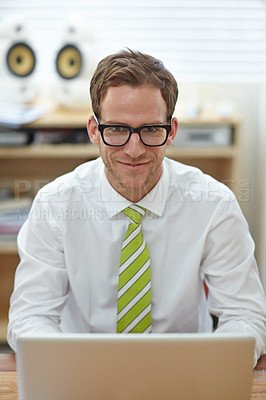 Buy stock photo A young businessman with glasses sitting behind his laptop