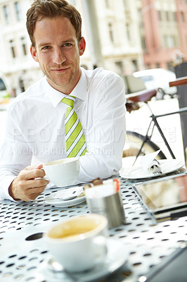 Buy stock photo A young businessman drinking coffee at an outdoor cafe