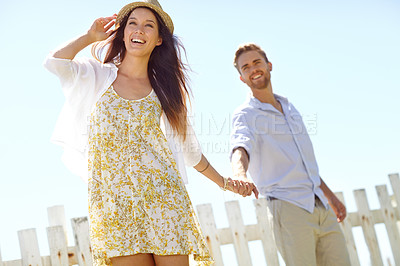 Buy stock photo Happy couple, hands and smile for summer vacation trip, travel or journey together in the outdoors. Beautiful woman leading her boyfriend by the hand on a sunny day for the holiday in the countryside