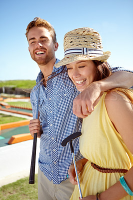 Buy stock photo Happy couple, mini golf and hug on summer date, fun activity and freedom in sunshine. Man, woman and young people playing outdoor games with love, happiness and quality time together on sunny day