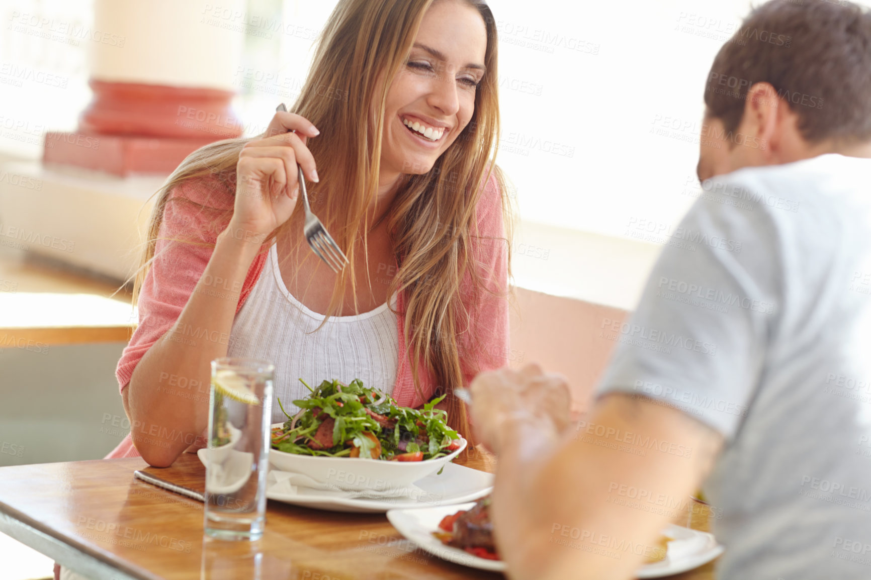Buy stock photo A happy young couple enjoying a tasty lunch in a restaurant