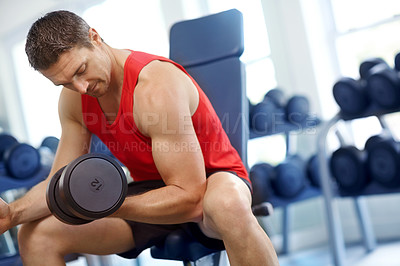 Buy stock photo A handsome young man doing weight training at the gym