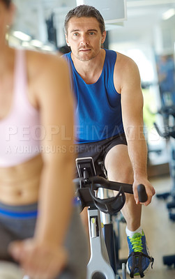 Buy stock photo Cardio, spin class or man cycling on bike machine in training and exercise for wellness, health or fitness. Athlete, active person and bicycle for legs workout, body or endurance in gym challenge