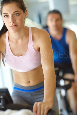 Buy stock photo A man and woman exercising in spinning class at the gym