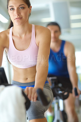 Buy stock photo A man and woman exercising in spinning class at the gym