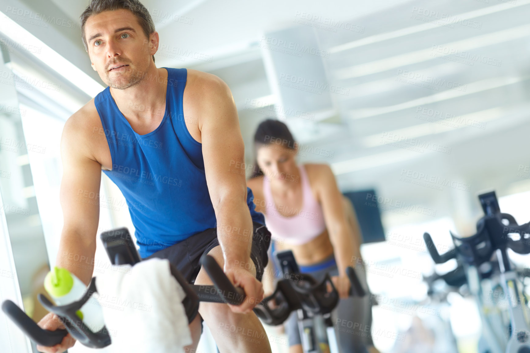 Buy stock photo A man and woman exercising in spinning class at the gym