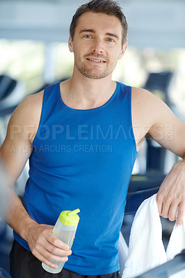 Buy stock photo A happy man leaning on a treadmill at the gym holding a water bottle