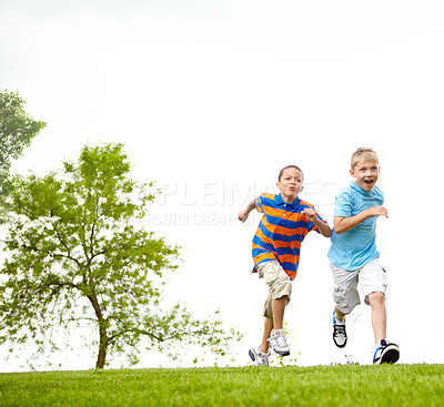 Buy stock photo Two little boys running through a park together and having fun