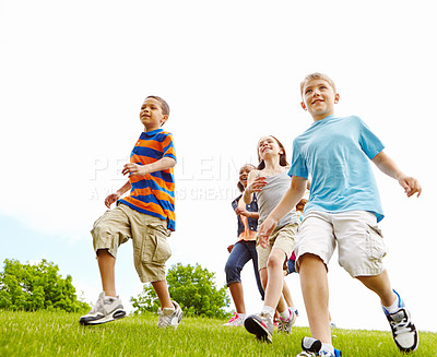 Buy stock photo Group of energetic children running through a park together