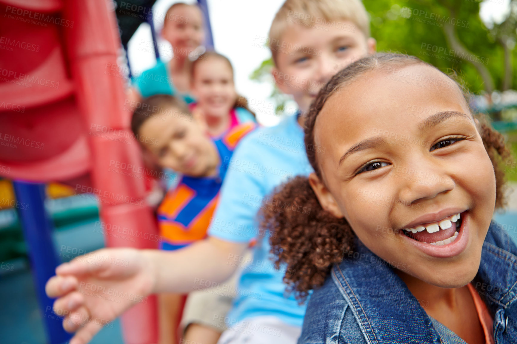 Buy stock photo A happy group of multi-ethnic children sitting happily on a slide in a play park