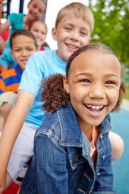 Buy stock photo A happy group of multi-ethnic children sitting happily on a slide in a play park