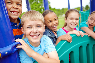 Buy stock photo A multi-ethnic group of happy children playing on a jungle gym in a play park