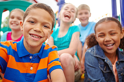 Buy stock photo A multi-ethnic group of happy children playing on a jungle gym in a play park