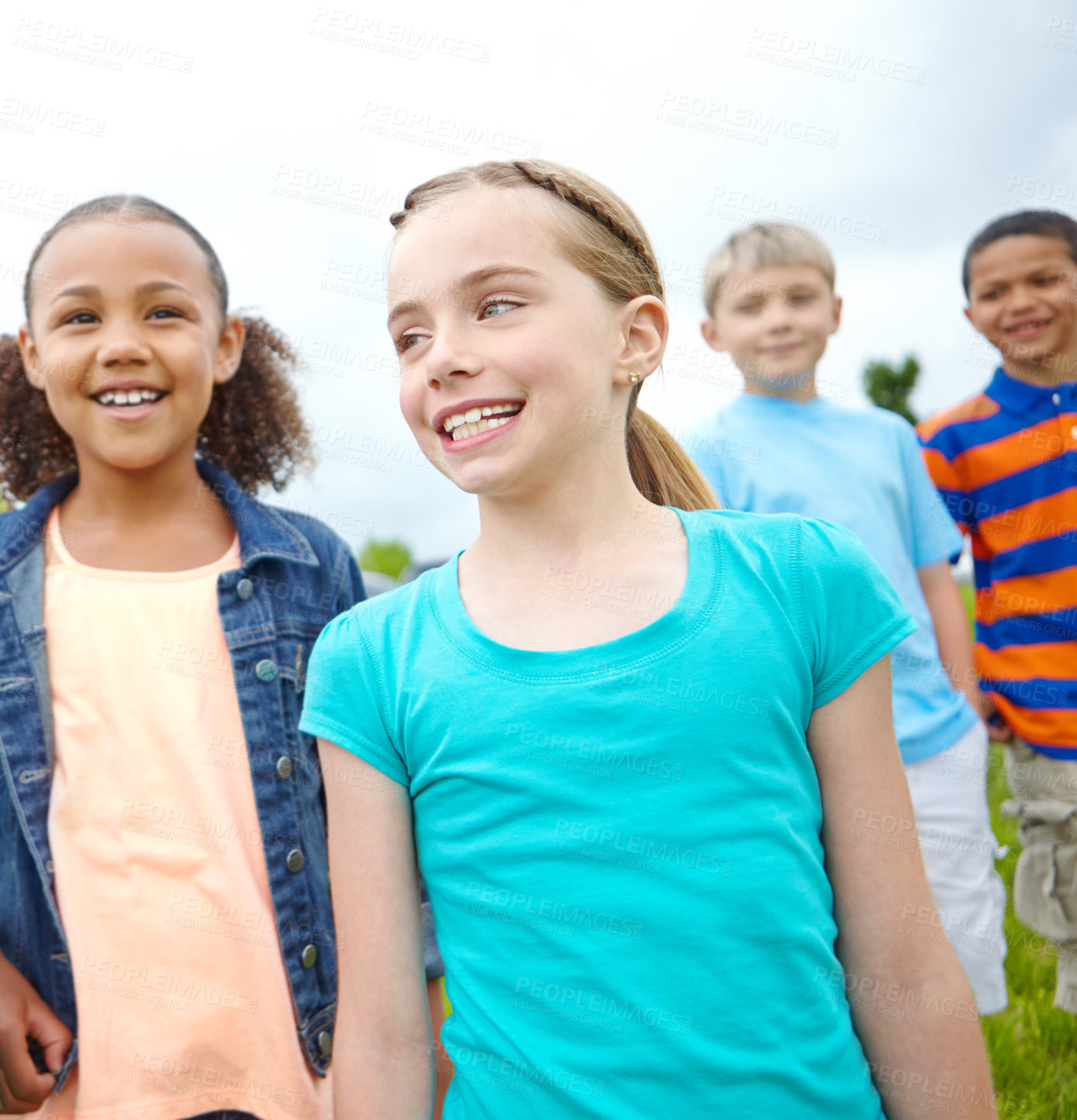 Buy stock photo A multi-ethnic group of kids standing outside in a park