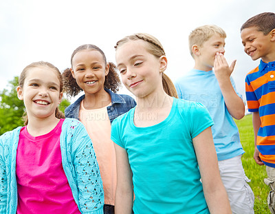 Buy stock photo A multi-ethnic group of kids standing outside in a park