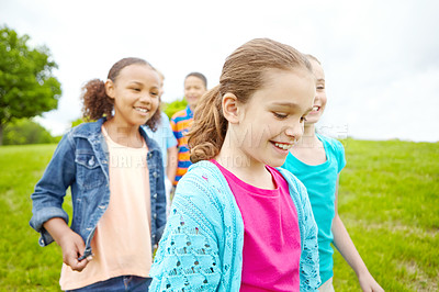 Buy stock photo A multi-ethnic group of happy kids walking outside in a park