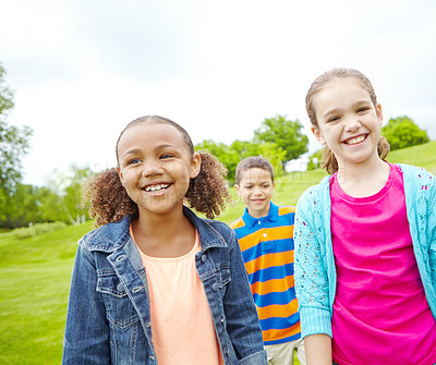 Buy stock photo A multi-ethnic group of kids standing outside in a park