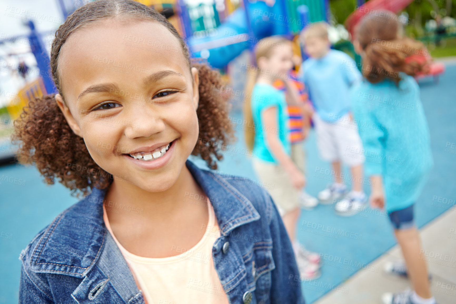 Buy stock photo A young girl smiling at the camera while her friends play behind her in a play park
