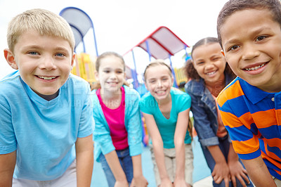 Buy stock photo A group of kids standing on the playground smiling at the camera