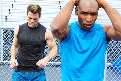 Buy stock photo Cropped shot of two male athletes wearing sports clothing and readying themselves for the race
