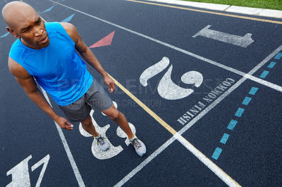 Buy stock photo High angle view of a male runner with a look of concentration in position to start the race