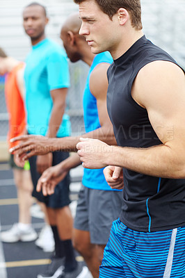 Buy stock photo Side view of a line up of male runners at the starting position on the track