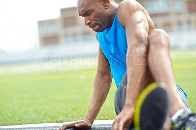 Buy stock photo Close up of a male athlete stretching in preparation for training