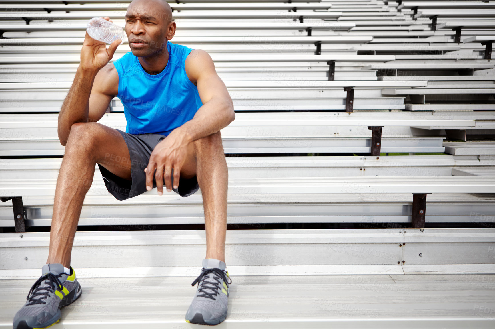 Buy stock photo Runner, drinking water and relax with black man in stadium for sports athlete, hydration break or health. Resting, wellness and electrolytes with person on stairs of training arena for exercise