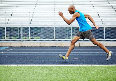 Buy stock photo Full length side view of a male runner running on the track