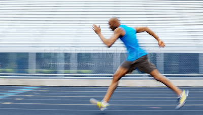 Buy stock photo Slightly blurred side view of a male athlete sprinting on the track