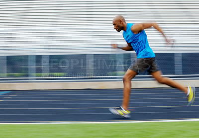 Buy stock photo Slightly blurred full length side view of a male athlete running quickly on the track