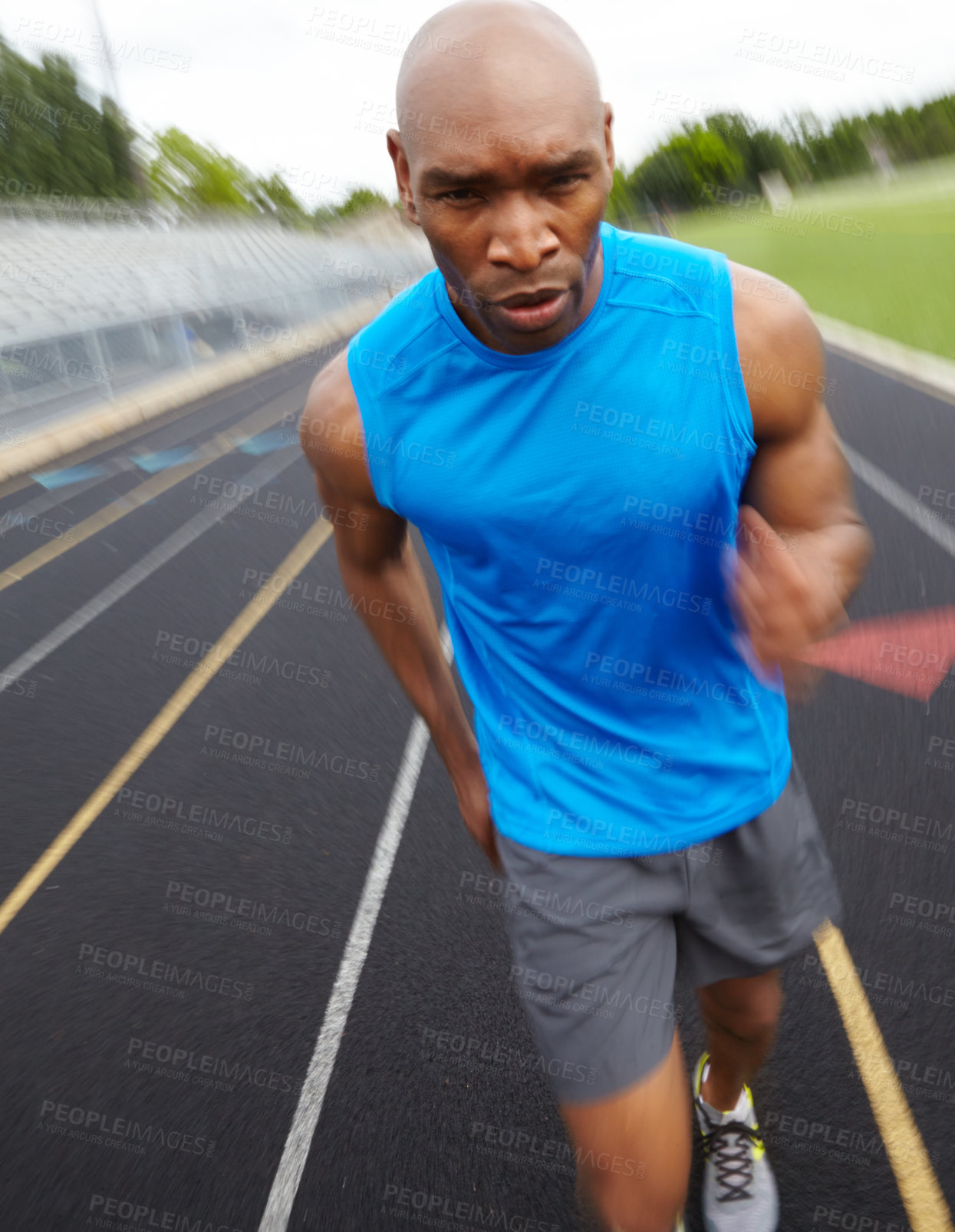 Buy stock photo Cropped front view of a focused male athlete running on the track