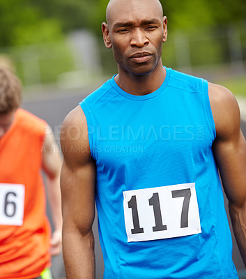 Buy stock photo Cropped front view of a male athlete with his racing number displayed on his sport shirt looking ahead with a determined expression