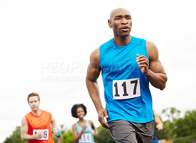 Buy stock photo Cropped front view of a driven male athlete running in first place