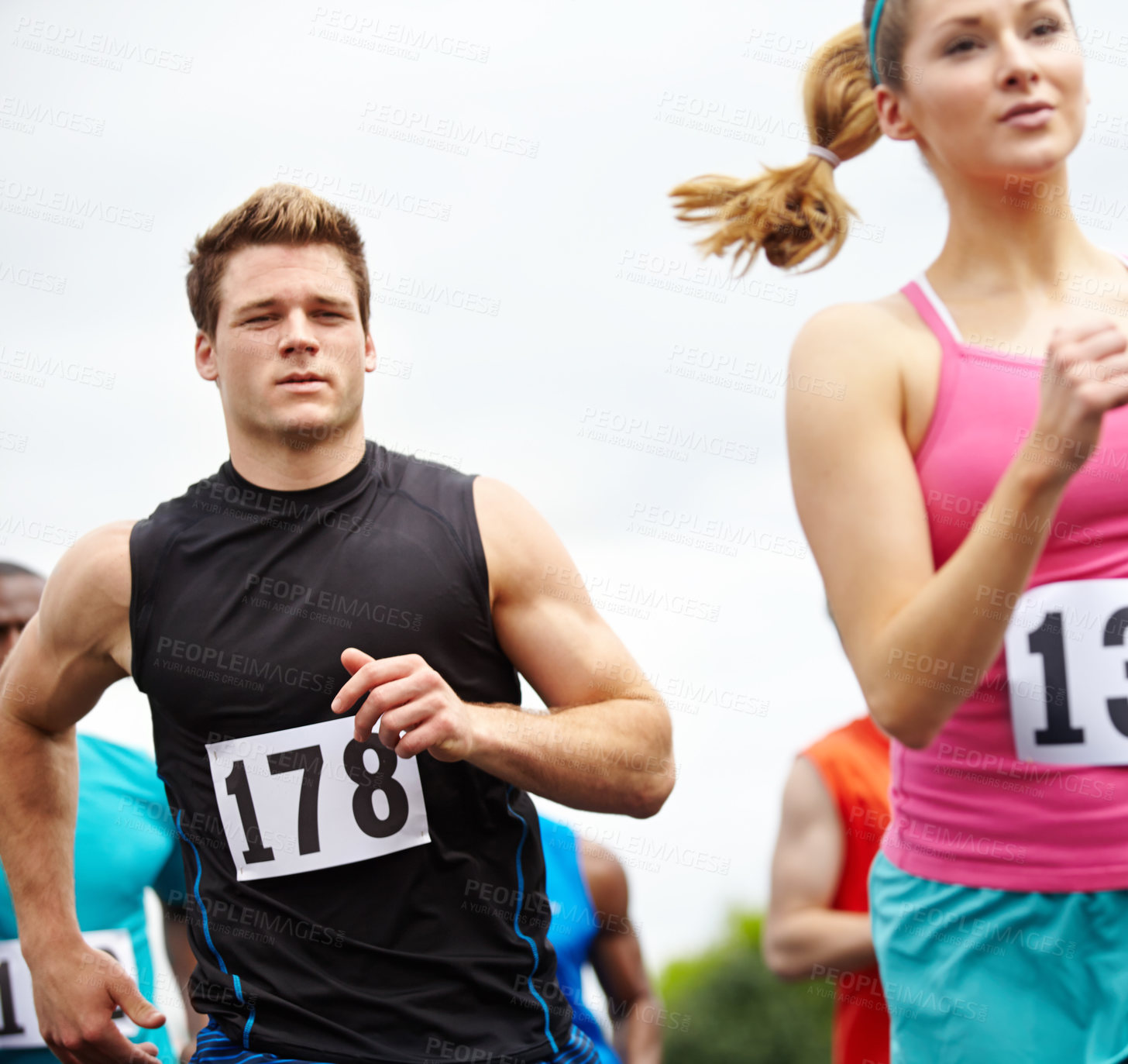 Buy stock photo Cropped shot of a group of runners with competitor numbers displayed on their sport shirts