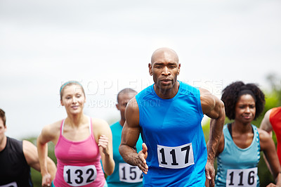 Buy stock photo Cropped shot of male and female athletes sprinting in a race