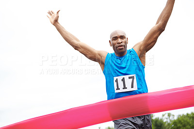 Buy stock photo Cropped front view of a male athlete winning a race with his arms raised