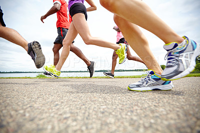 Buy stock photo Low angle side view of athletes running on an outdoor track