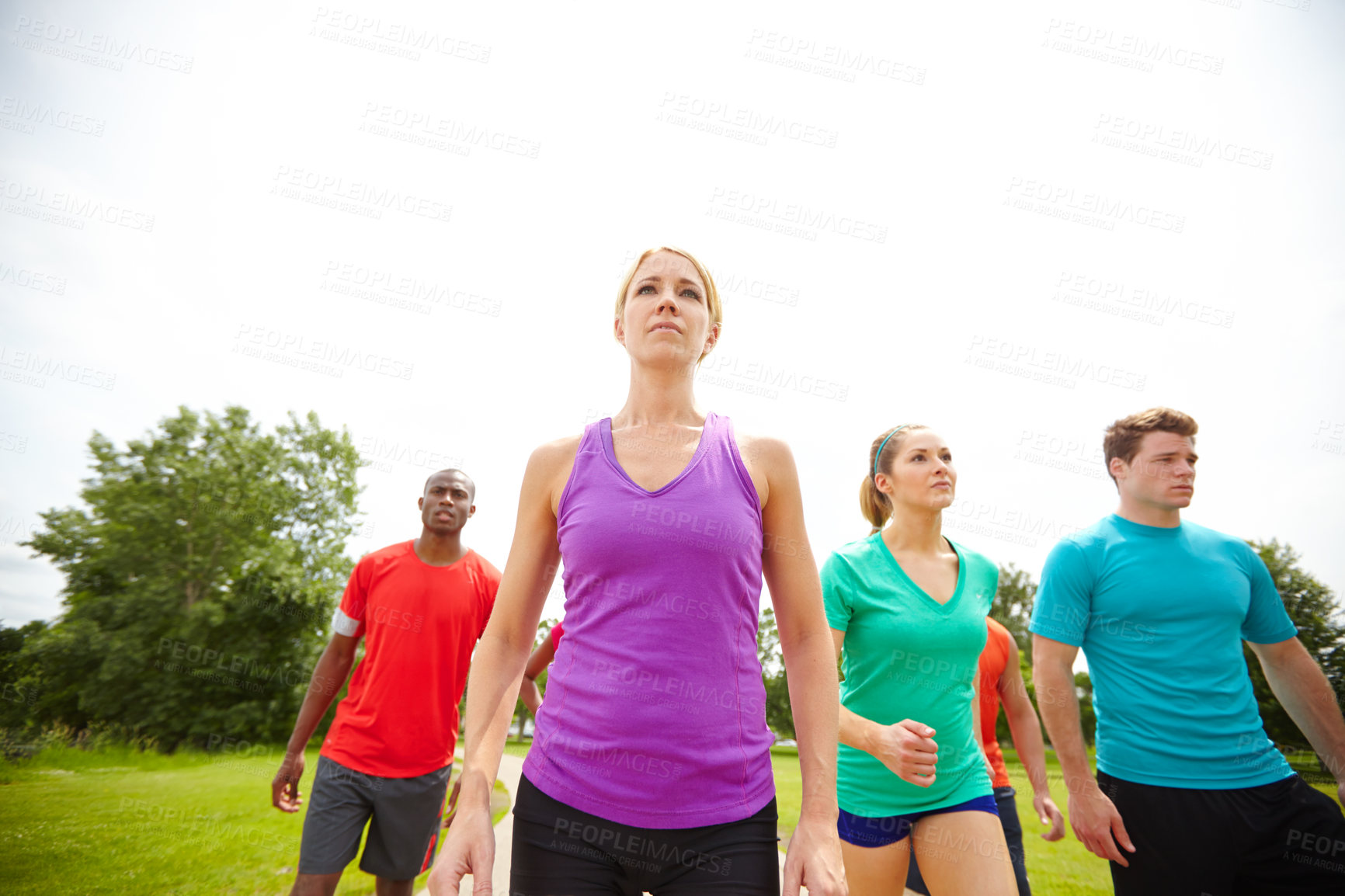 Buy stock photo Low angle shot of a group of athletes exercising outdoors