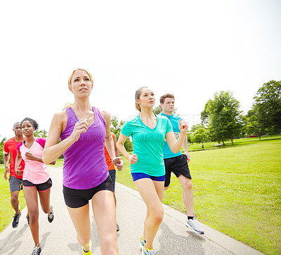 Buy stock photo Front view of a group of male and female athletes running outside