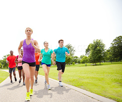 Buy stock photo Front view of a group of male and female athletes running on an outdoor track