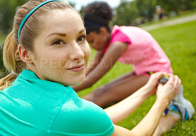 Buy stock photo Cropped shot of a female athlete looking over her shoulder while stretching