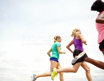 Buy stock photo Cropped side view of a group of athletes jogging outdoors