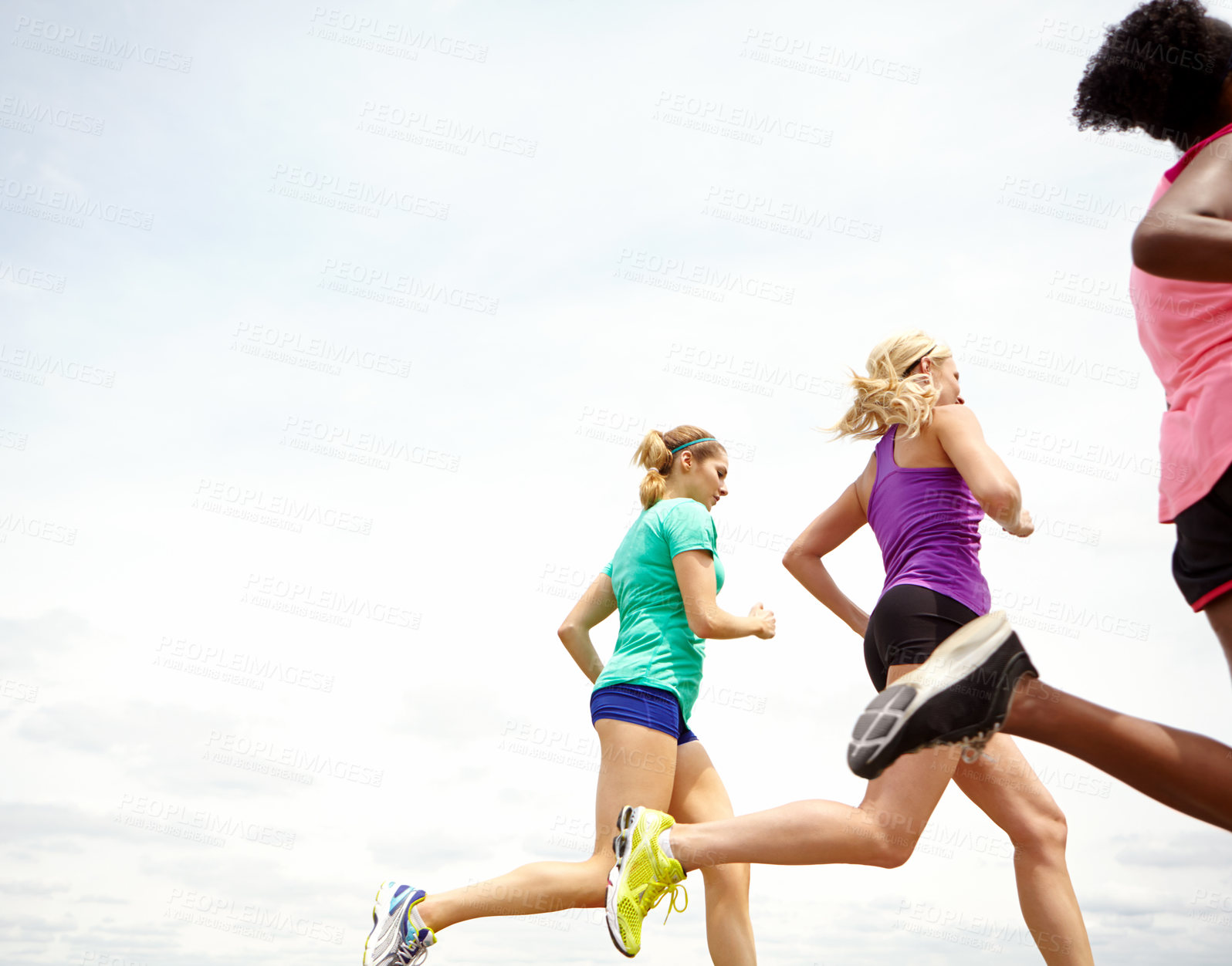 Buy stock photo Cropped side view of a group of athletes jogging outdoors